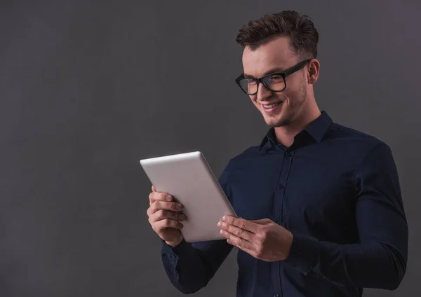 Bonito Jovem Empresário Óculos Está Usando Tablet Digital Sorrindo Fundo — Fotografia de Stock