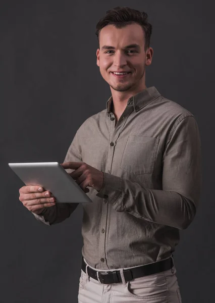 Pohledný Mladý Podnikatel Neformálním Oblečení Drží Digitální Tabletu Při Pohledu — Stock fotografie