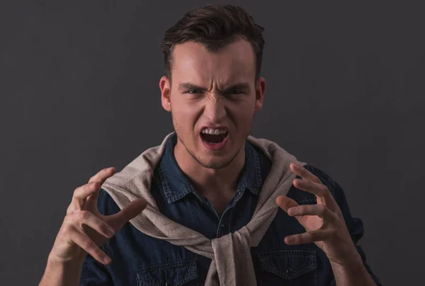 Guapo Joven Está Haciendo Caras Garras Cámara Sobre Fondo Gris — Foto de Stock