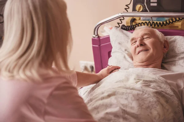 Cheerful Old Man Looking His Wife Smiling While Lying Bed — Stock Photo, Image