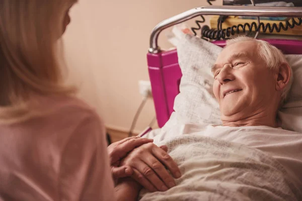 Wesoły Staruszek Patrzy Żonę Uśmiechając Się Leżąc Łóżku Oddziale Szpitala — Zdjęcie stockowe
