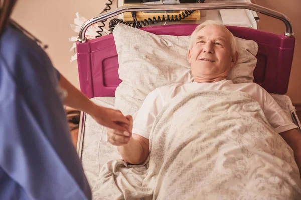 Vrolijke Oude Man Zoek Naar Verpleegkundige Holding Haar Hand Glimlachen — Stockfoto