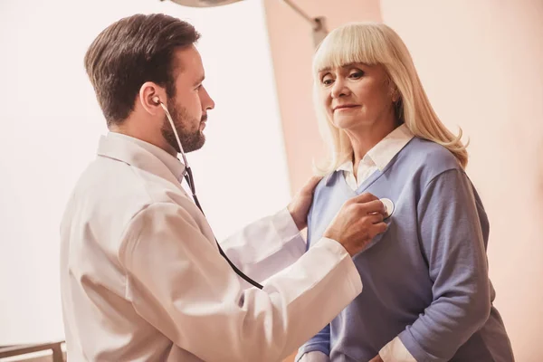 Schöner Arzt Hört Mit Einem Stethoskop Dem Herzschlag Einer Alten — Stockfoto