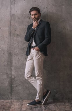 Gri arka plan üzerinde kamera poz yakışıklı emin işadamı ile kıl, takım, tam uzunlukta portresi