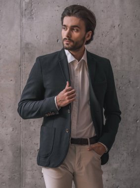 Takım, kıl ile yakışıklı emin işadamı, gri arka plan üzerinde arıyor