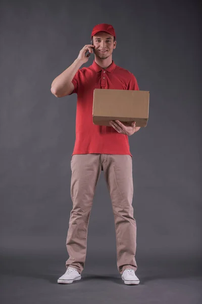 Imagen Completa Del Joven Guapo Repartidor Uniforme Hablando Teléfono Móvil — Foto de Stock