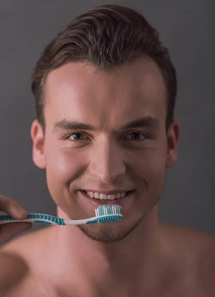 Retrato Joven Guapo Sosteniendo Cepillo Dientes Mirando Cámara Sonriendo Sobre —  Fotos de Stock