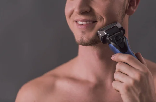 Imagen Recortada Joven Guapo Afeitándose Con Una Afeitadora Eléctrica Sonriendo — Foto de Stock