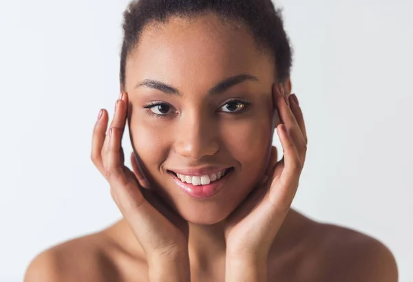 Hermosa Chica Afroamericana Está Tocando Cara Mirando Cámara Sonriendo Aislada —  Fotos de Stock