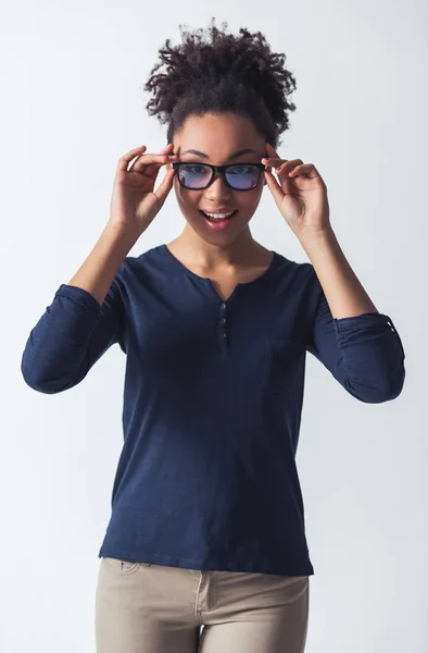 カジュアルな服と眼鏡でアフリカ系アメリカ人美少女カメラ目線と白で隔離 笑みを浮かべて — ストック写真
