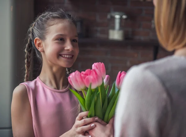 Ragazzina Sta Dando Fiori Sua Madre Sorridente Mentre Piedi Cucina — Foto Stock