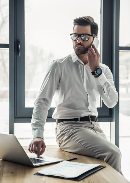 Hombre Negocios Guapo Gafas Está Hablando Teléfono Móvil Uso Ordenador — Foto de Stock