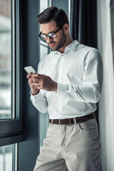 Knappe Ernstige Zakenman Brillen Met Behulp Van Een Smartphone Terwijl — Stockfoto