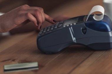 Afro Amerikan barista bir ödeme sayacı, çalışırken terminal kullanarak kırpılmış görüntü