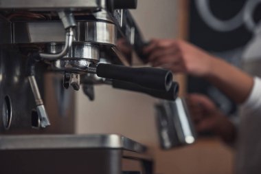 Afro Amerikan barista kahve makinesi kullanarak kahve hazırlama görüntü kırpılmış, makine ayrıntılara odaklanmak