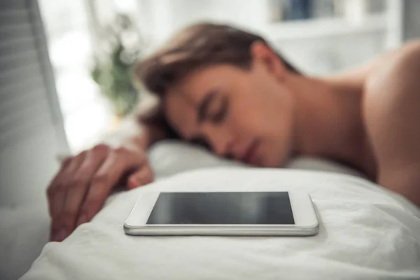 Przystojny Młody Człowiek Śpi Łóżku Jego Smartphone Jest Poduszce Pobliżu — Zdjęcie stockowe