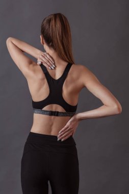 Spor giyim, güzel kızı arkadan görünüm gri arka plan üzerinde
