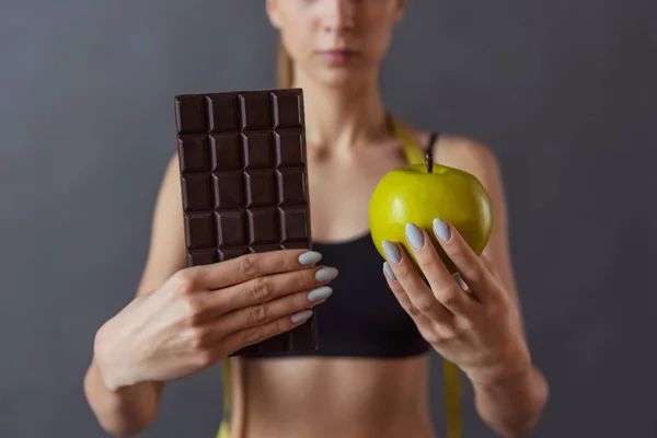 Cropped Image Beautiful Girl Sportswear Holding Apple Bar Chocolate Gray — Stock Photo, Image