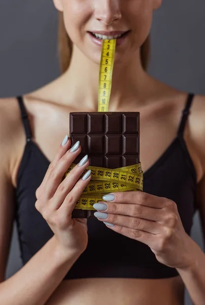 Cropped Image Girl Biting Tape Measure Wrapped Chocolate Bar Gray — Stock Photo, Image