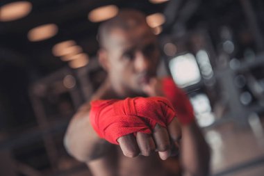 Afro Amerikalı boksör, kırmızı bandaj içinde sarılı elleri olduğunu eğitim salonunda, odakta el