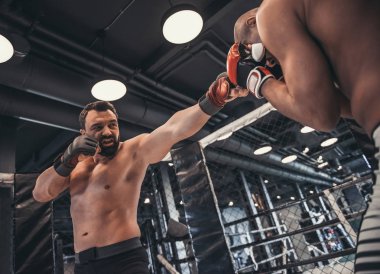 Boks eldivenleri ve şort iki adam kafese mücadele ediyoruz