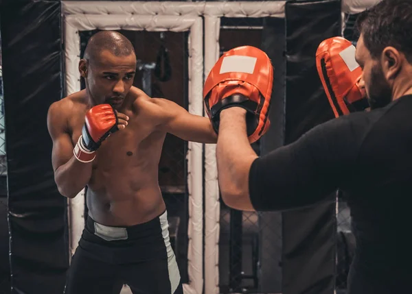 手袋でアフロのアメリカのボクサーはボクシングのリングでコーチとトレーニング — ストック写真