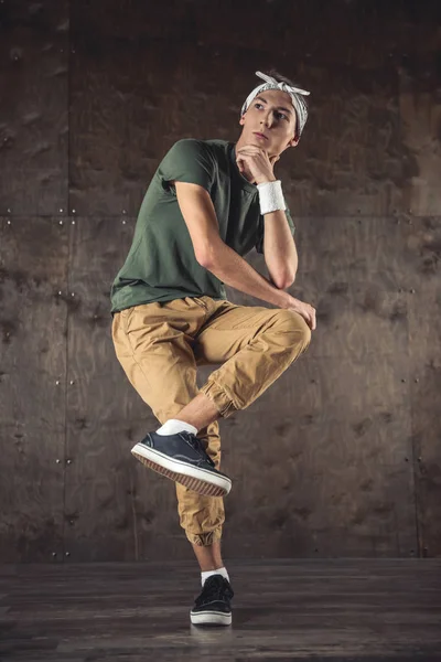 Young man break dancing on the wall background, performing tricks