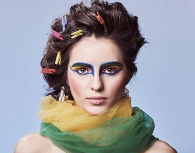 Güzellik portresi. Moda. Yaratıcı -lık. Renkli bir saç modeli ve makyaj ile genç kadın kameraya bakıyor