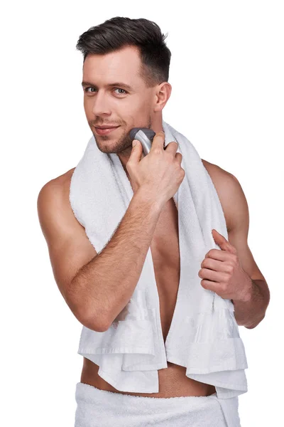 男人的美丽 英俊的男人的肖像包裹在毛巾使用电动剃须刀和微笑 孤立在白色 — 图库照片