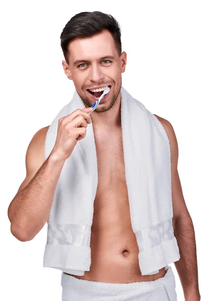 歯科治療 白で隔離 彼の歯を磨くタオルに包まれたハンサムな男の肖像 — ストック写真