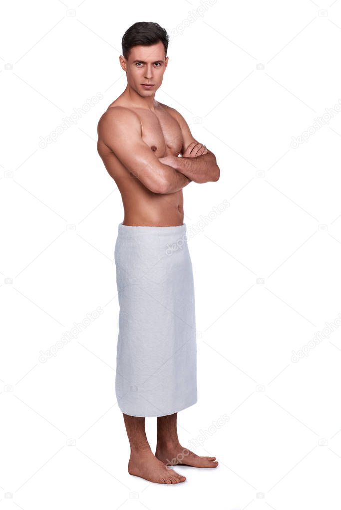 Men's beauty. Full-length portrait of handsome man wrapped in towel, isolated on white