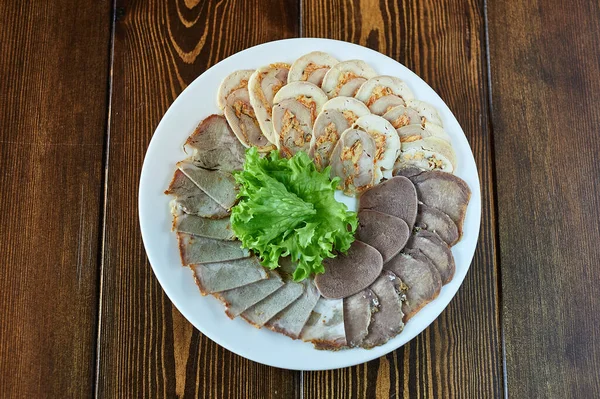 Tahta bir masanın üstünde bir tabak yemek.