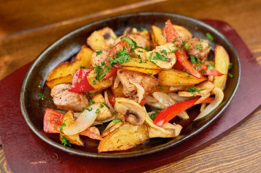 Tahta bir masada bir tabak yemek.