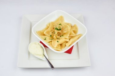 Beyaz arka planda ekşi krema ve sebzeli hamur tatlısı.