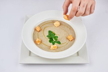 Elinde bir tabak yemek tutan bir insan.