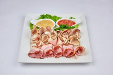 Beyaz arka planda yeşil yapraklı hardal ve turplu et tabağı. 