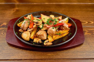 Tahta bir masada bir tabak yemek.