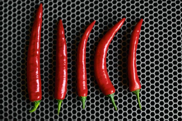 Pimientos rojos picantes verticalmente se cierran sobre un fondo oscuro — Foto de Stock