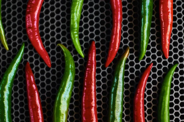 Pimenta verde quente e pimenta vermelha em um fundo escuro perto ereto — Fotografia de Stock