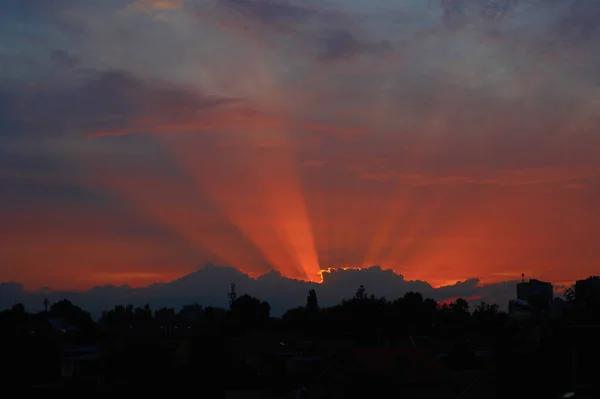 Tramonto rosso attraverso le nuvole sul cielo blu orizzontalmente — Foto Stock