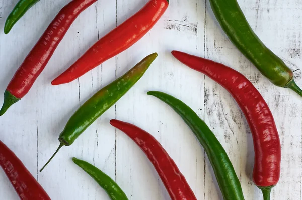 Pimenta verde e vermelha picante em um fundo claro de cima de perto — Fotografia de Stock