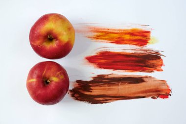 Beyaz arkaplanda kırmızı elmalar, yukarıdan yatay olarak lekelenmiş.