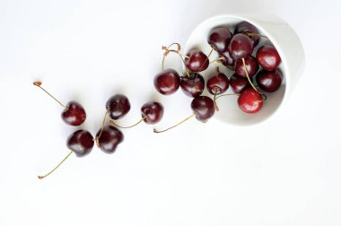 Beyaz arka planda sostan yayılmış kiraz.