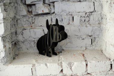 Beyaz tuğla arka plandaki köpek figürü yatay olarak çekildi