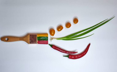 hafif bir arka planda sebzeler ve boyalarla yatay olarak yakın plan fırça 