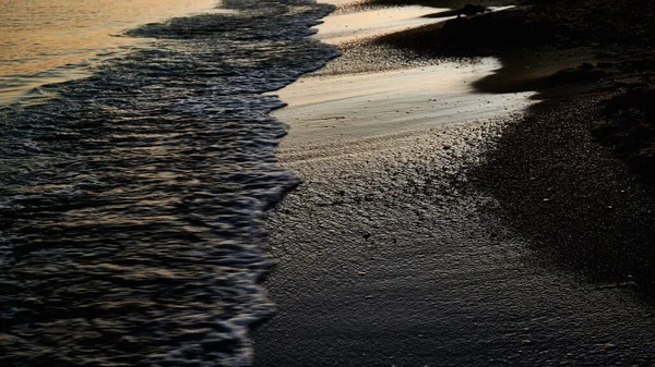 Espuma do mar, linha de praia ao pôr do sol, areia molhada, fundo — Fotografia de Stock