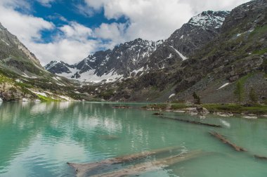 Dağ gölünün manzarası. Mavi gökyüzü, doğa bulutlarıyla.