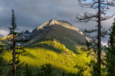 Güneş ışığı bulutların arasından Altai Dağları 'na düşüyor.