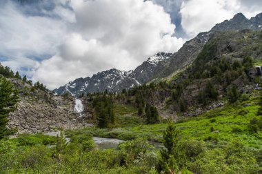 Altai Dağları 'ndaki dağların arka planına karşı şelale. 