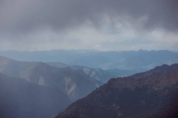 Nubes lluviosas sobre el telón de fondo de las altas montañas en las montañas de Altai —  Fotos de Stock